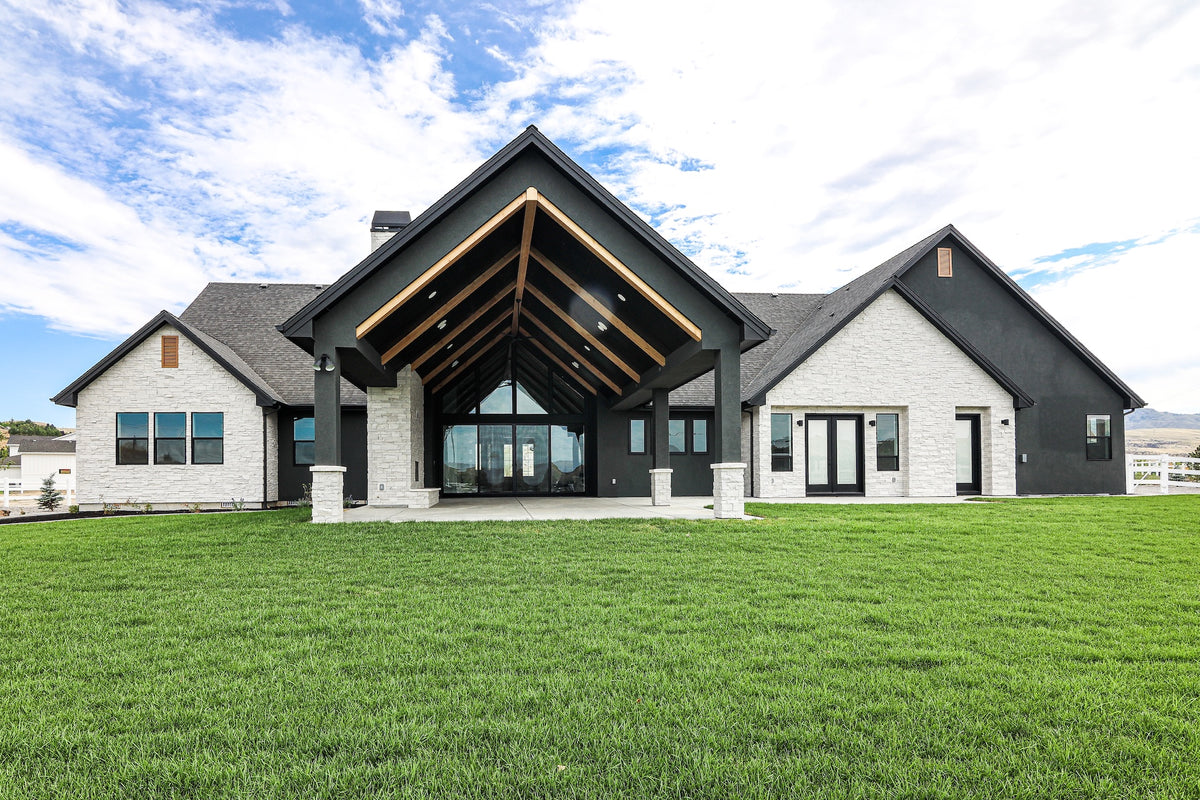 Modern house with a gray exterior and wooden accents on a clear day.