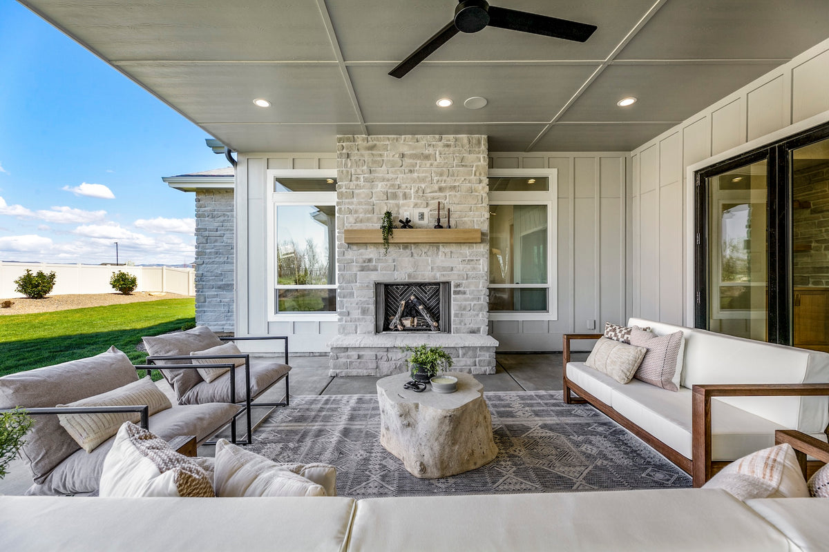 Modern outdoor living space with patio furniture and fireplace.