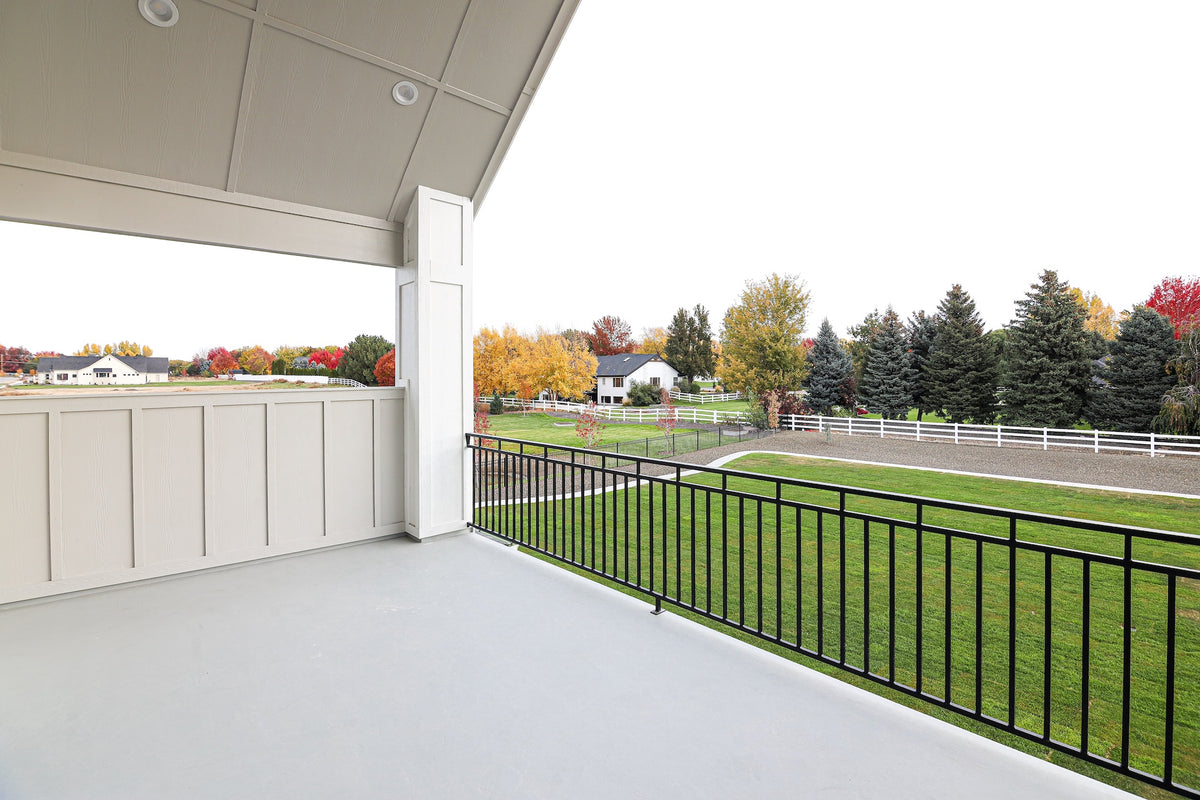 Covered outdoor area with a view of a grassy field and trees
