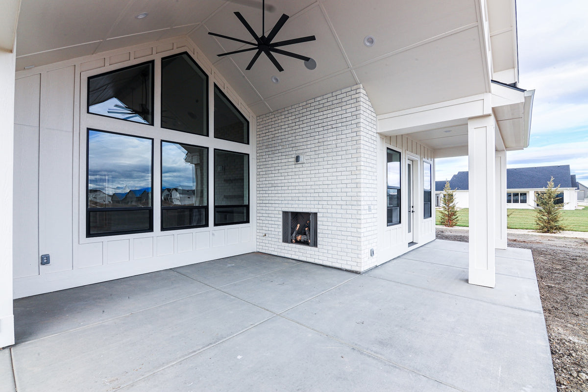 Modern house exterior with large windows and a white brick wall.