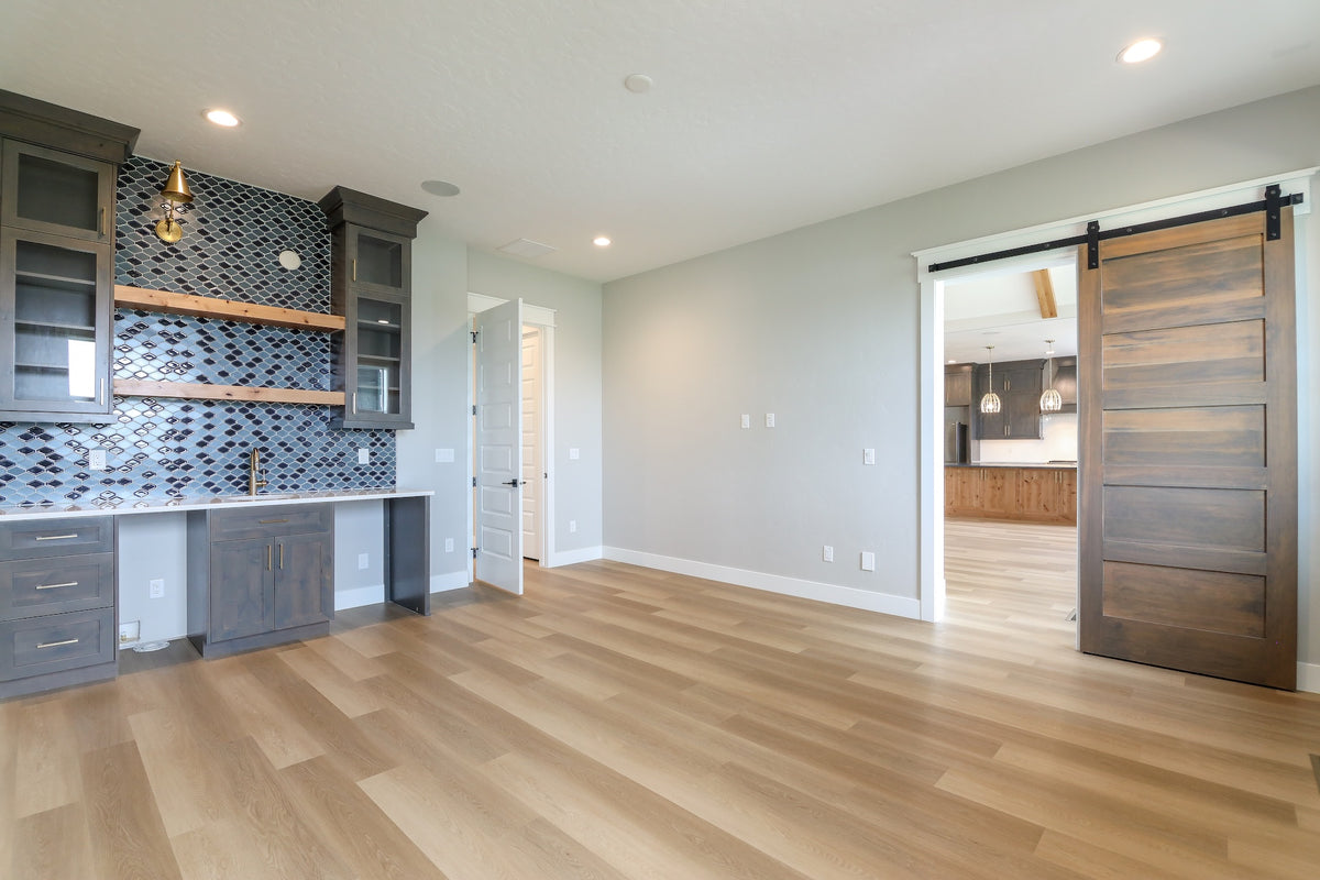 Modern kitchen with wooden cabinets, tiled backsplash, and a sliding wooden door.