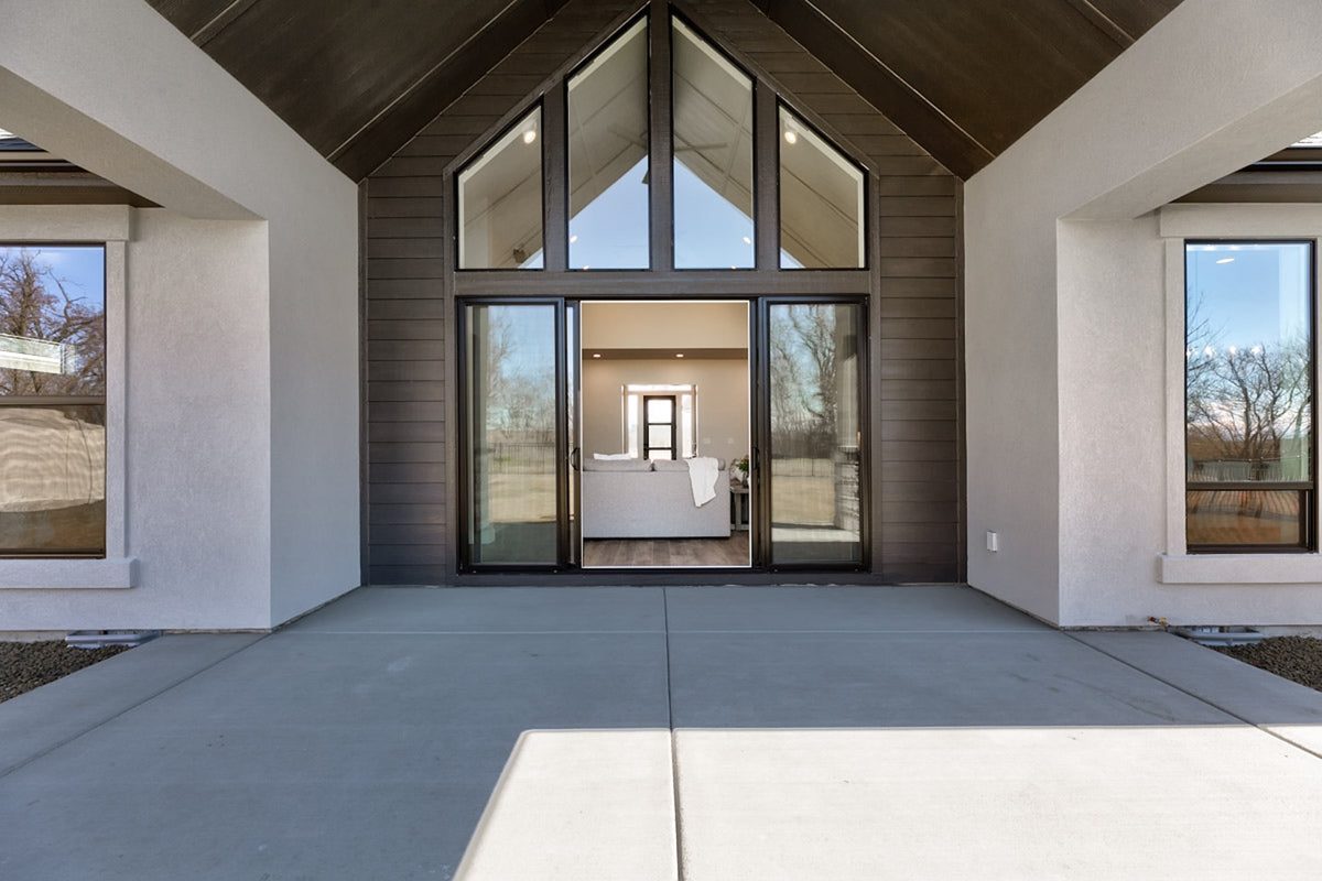 Modern house interior with large glass windows and a vaulted ceiling.