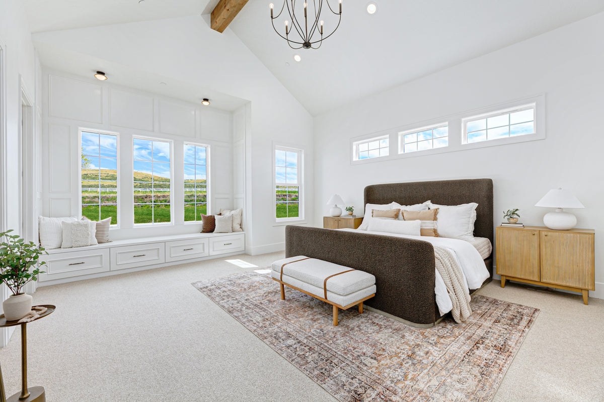 Spacious bedroom with large windows, a bed, and decorative elements.
