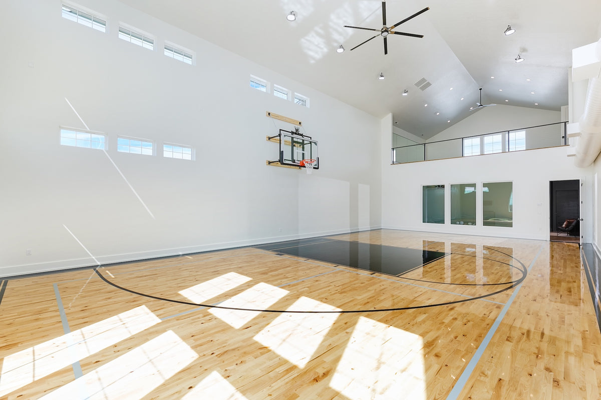 Indoor basketball court with wooden floor and white walls