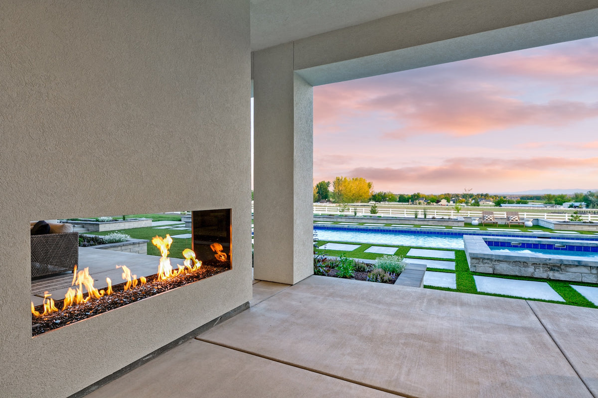 Modern indoor fireplace with a view of a pool and garden outside