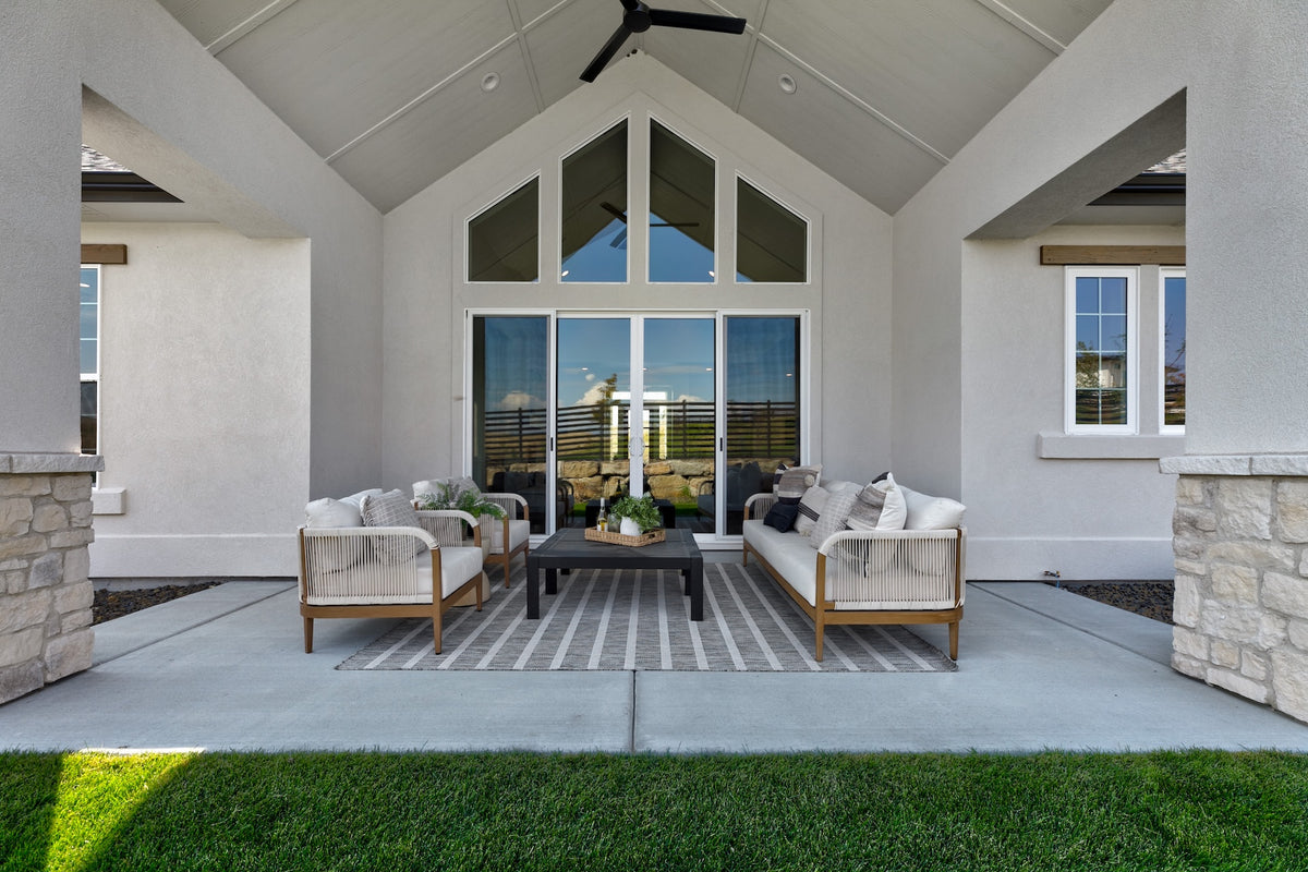 Outdoor patio area with furniture and a view of the house's interior.