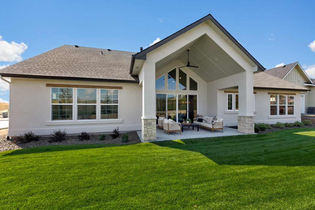 Modern house with a large covered porch and green lawn