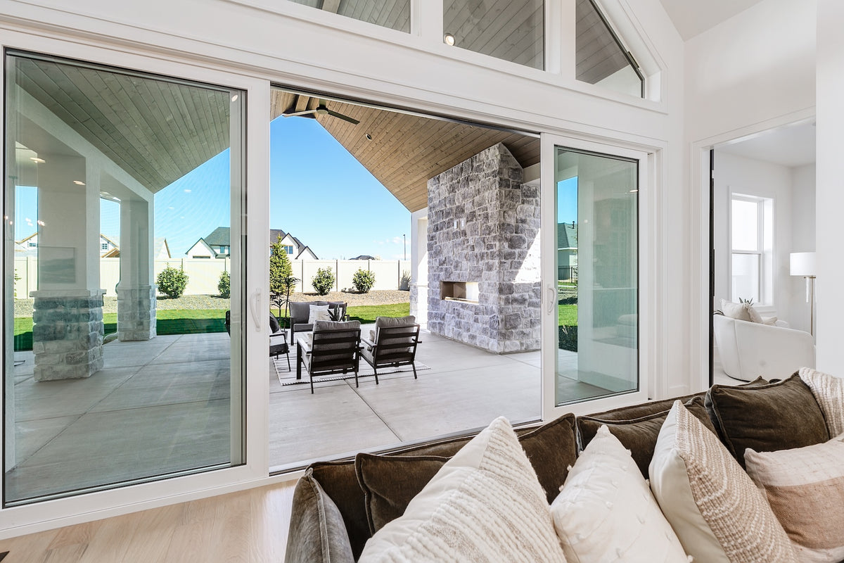 Modern living room with large windows overlooking a patio and garden.