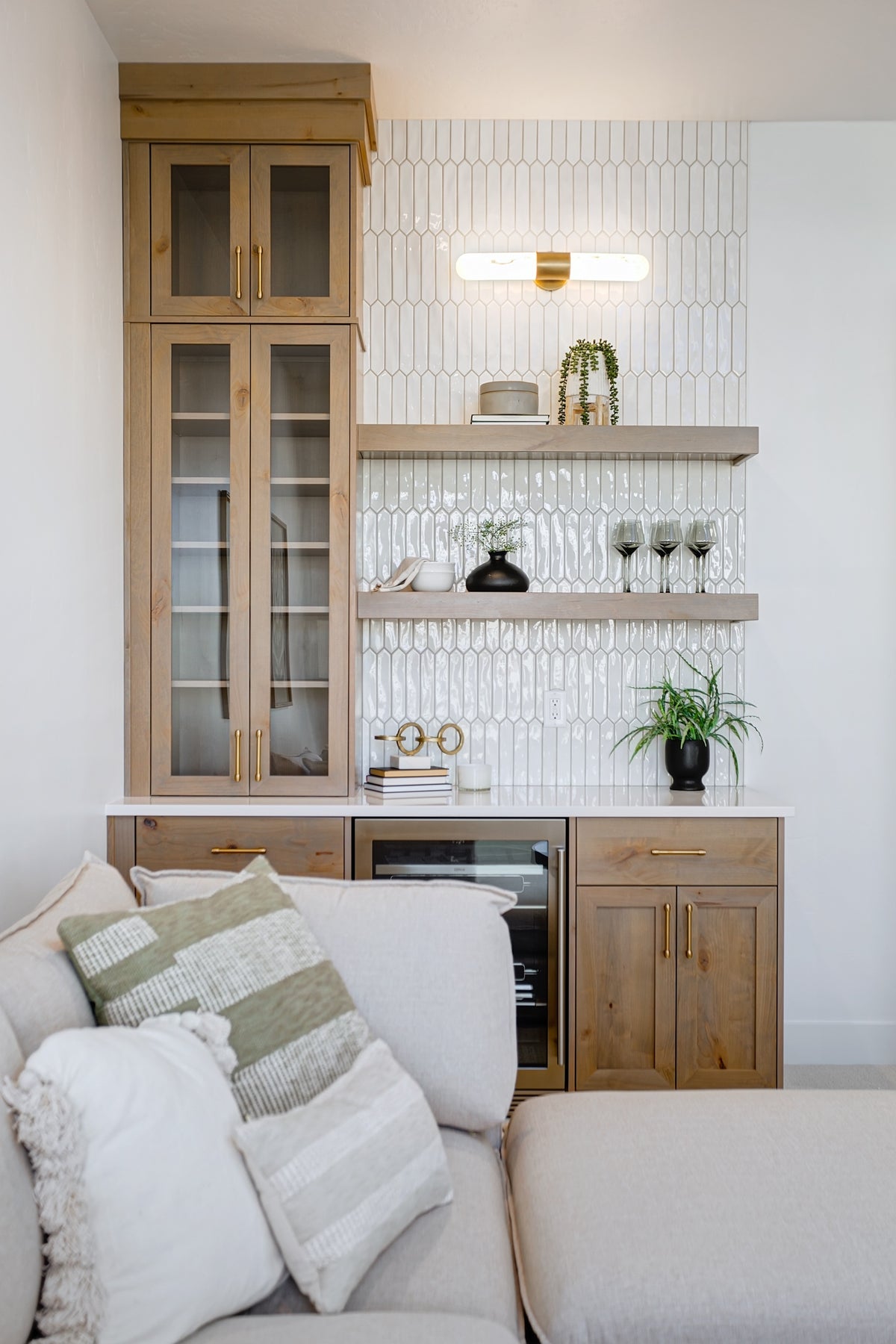 Modern living room with wooden cabinets, white walls, and a gray sofa.