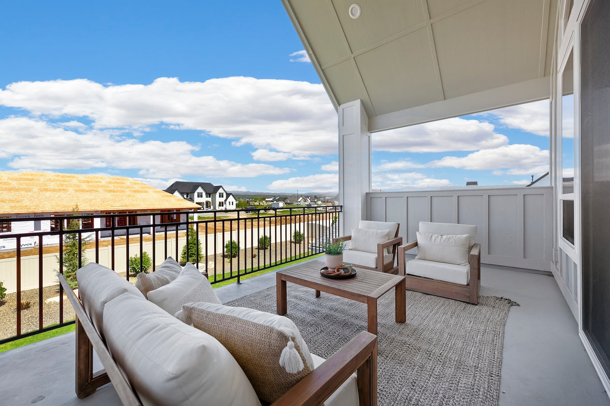 Outdoor patio area with white furniture and a view of a residential neighborhood.