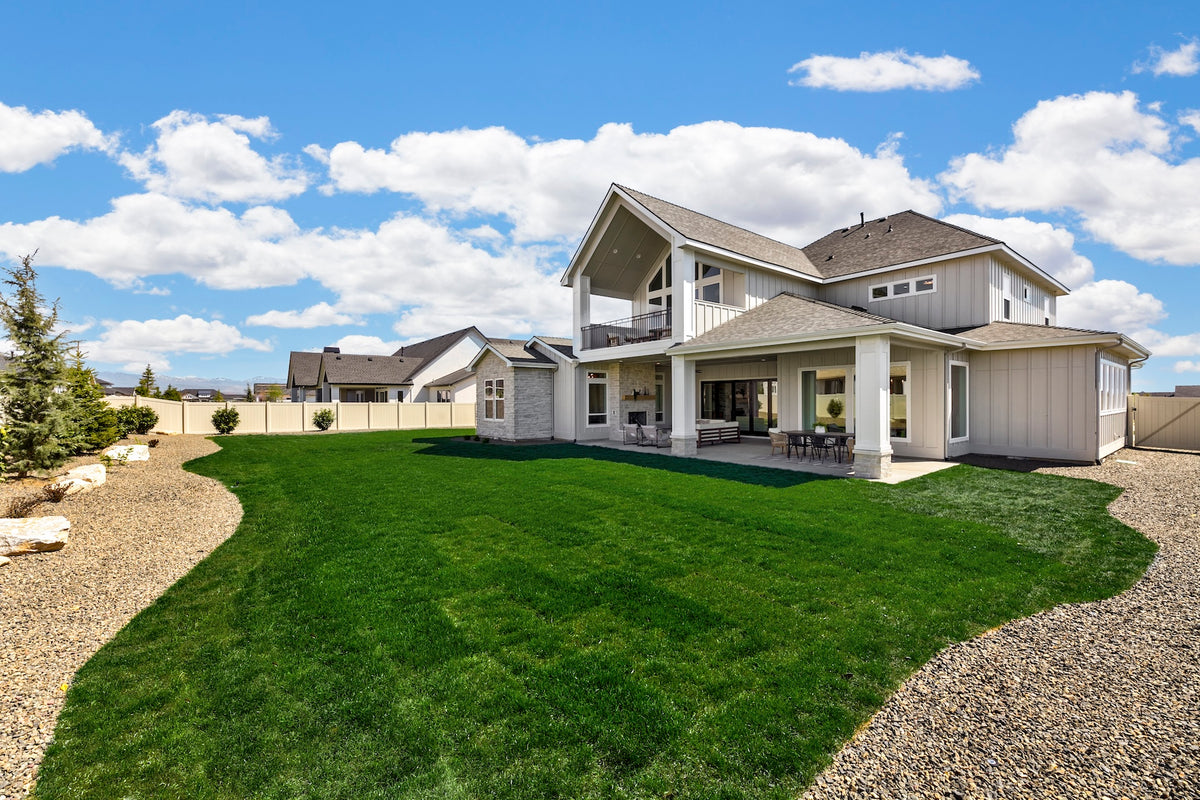 Large modern house with a well-maintained lawn and clear sky