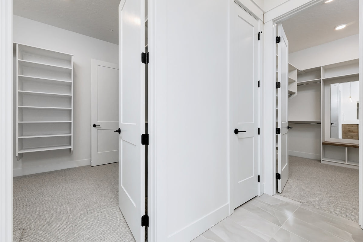 Closet with white doors and shelves in a bright room