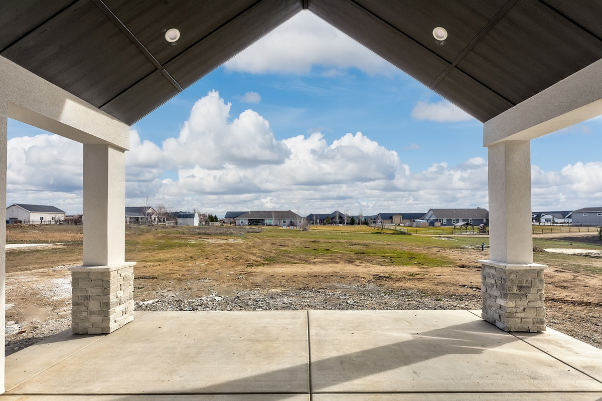 Covered outdoor area with a view of a development site and blue sky.