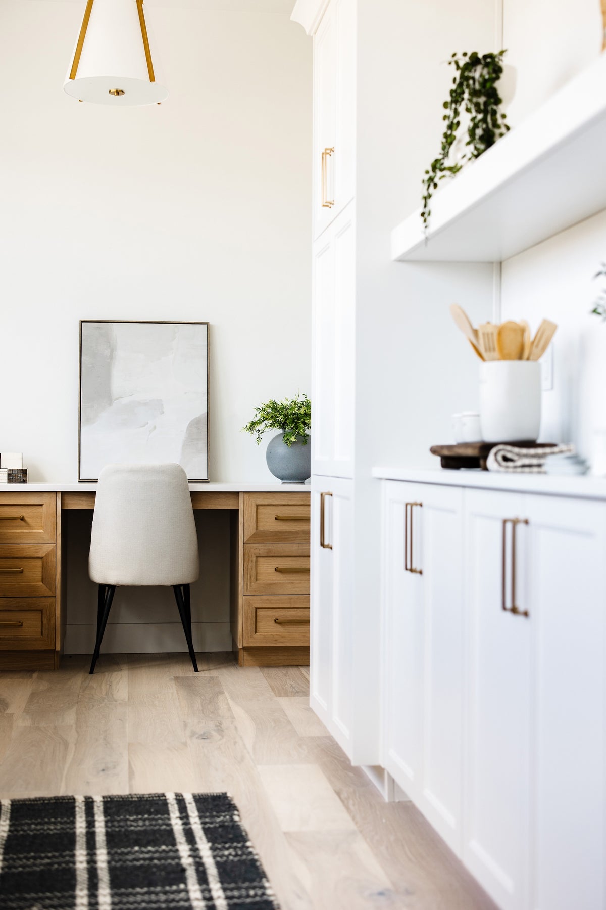 Modern kitchen with white cabinets, a countertop, and a chair.