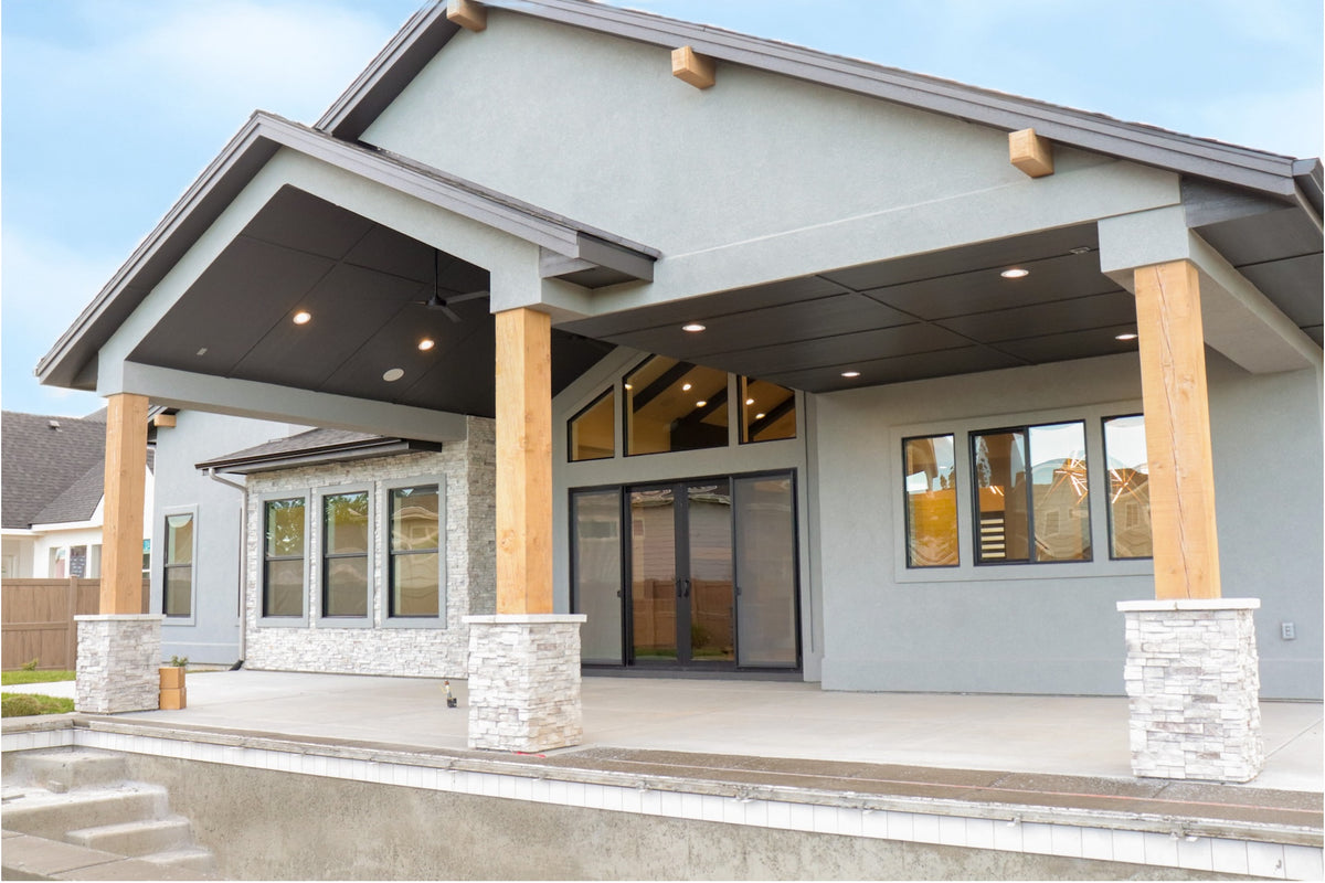 Modern house exterior with a covered entrance and wooden columns.