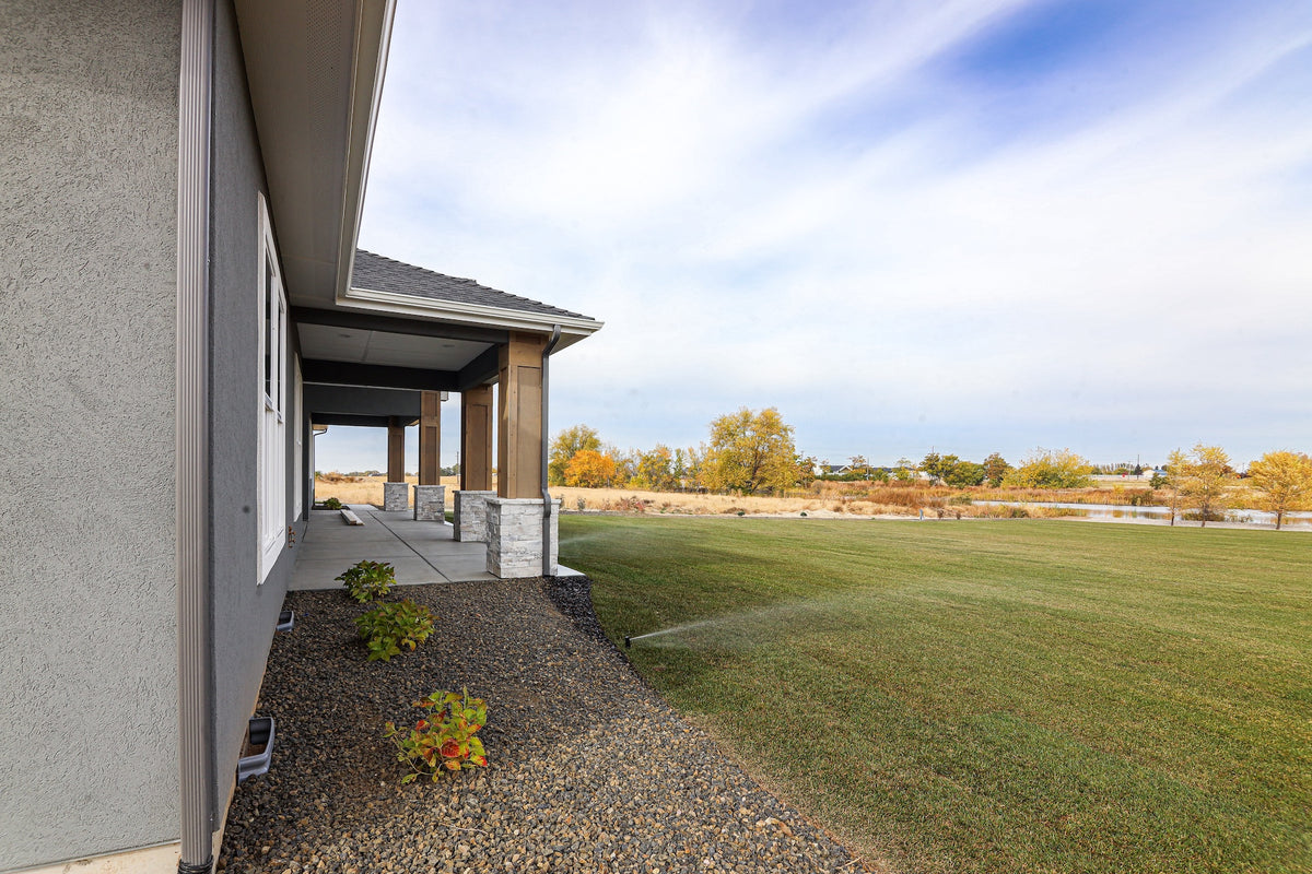Modern house exterior with a well-maintained lawn and clear sky