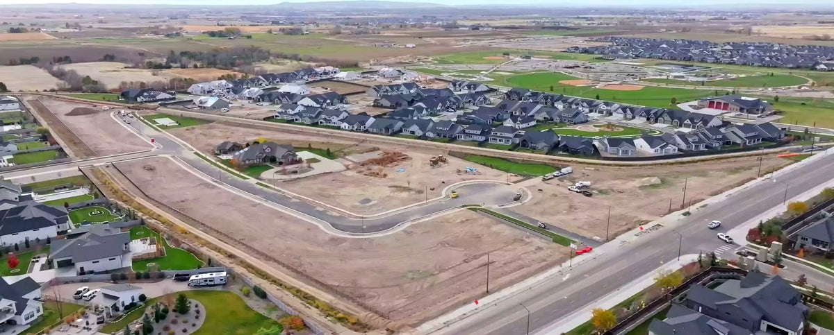 Aerial view of a residential development with houses and open land.