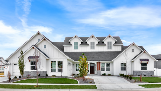 A front view of a white, two-story residential house with a gable roof, garage, and a porch.